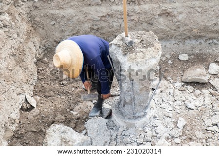 A construction worker cuts a concrete bored pile at pile's cut off level.