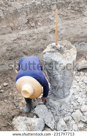A construction worker cuts a concrete bored pile at pile\'s cut off level.