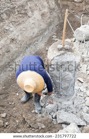 A construction worker cuts a concrete bored pile at pile\'s cut off level.