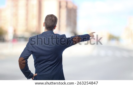Man in suit pointing back in a city
