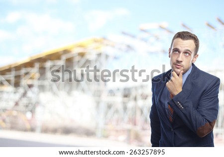 Man in suit thinking in front of Building structure