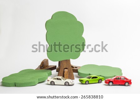 House of wooden blocks of different colors, three wooden figures of trees, euro money, three models of cars, keychains