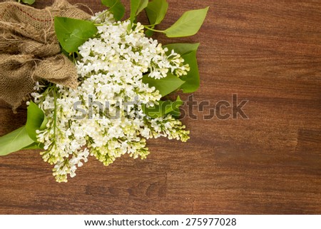 white lilac, lilac purple, white sheet of paper with hearts punching, punching with flowers on turquoise background, on a brown background,