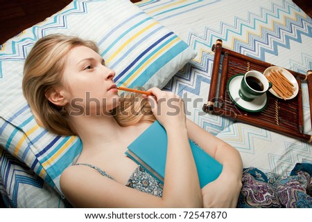 dreaming girl with cup of coffee and blue notebook