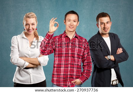Teamwork concept. Asian man smiling, looking on camera, showing OK