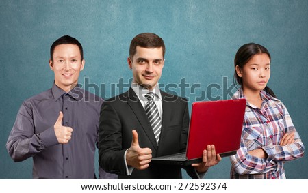 Team and male businessman in suit with laptop in his hands, looking on camera