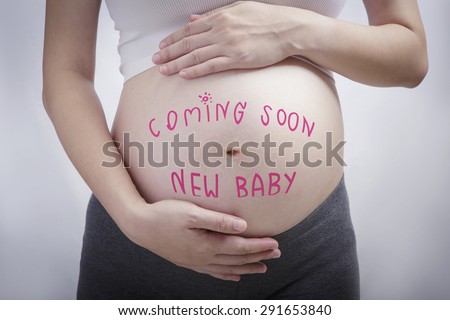 Pregnancy writing the word coming soon new baby on stomach, pregnancy and newborn baby