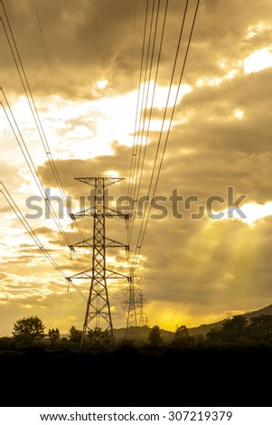 Energy Distribution Network - Electricity Pylons against Orange and Yellow Sunset - Vibrant color effect