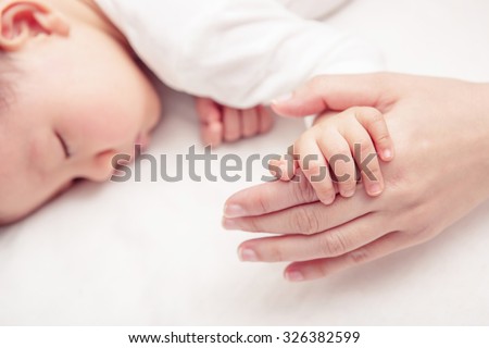 Hand the sleeping baby in the hand of mother close-up (Soft focus and blurry)