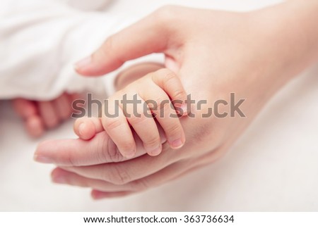 Hand the sleeping baby in the hand of mother close-up (Soft focus and blurry)