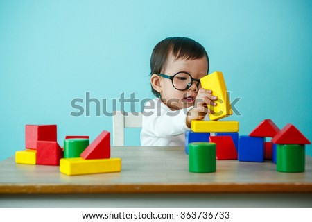 kid toddler playing wooden toys at home or nursery