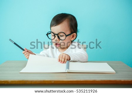 Newborn smiling wearing glasses, on the table (soft focus on the eyes)
