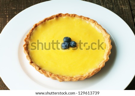 Fresh Meyer Lemon tart with golden pastry crust and blueberries