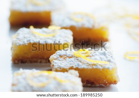 Zesty sweet lemon bars with lemon garnish and confectioner\'s sugar