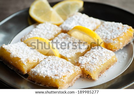 Zesty sweet lemon bars with lemon garnish and confectioner\'s sugar
