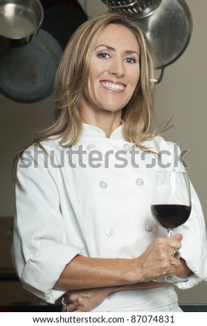 Blond woman in white chef coat holding glass of red wine/Professional Chef
