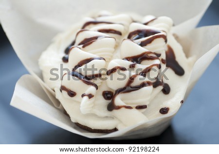 Fresh cupcake  with butter cream frosting and chocolate syrup
