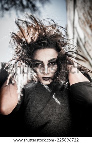 Long hair girl with scary makeup on the old church background