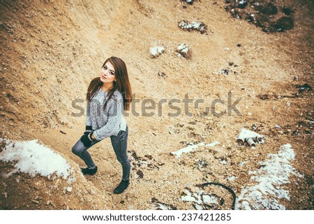 Pretty young woman outdoor in quarry with sand on background