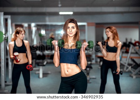 Three pretty girls workout in the gym