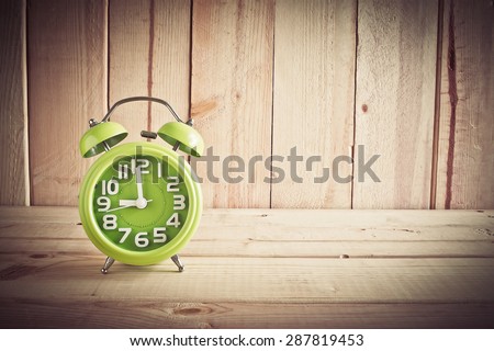 Alarm clock on wooden table over wood background, Still life style