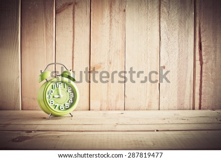 Alarm clock on wooden table over wood background, Still life style