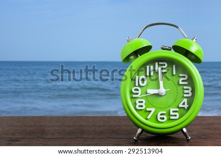Clock on Wooden Floor with Blue Sea Background