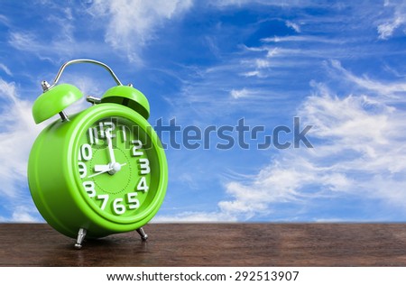 Clock on Wooden Floor with Blue Sky Background