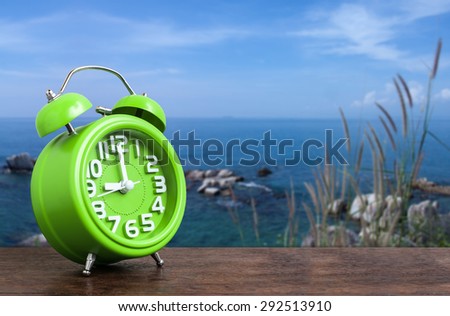 Clock on Wooden Floor with Blue Sky and Hillock  Background