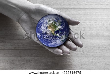 Woman holding global in hand , Elements of this image furnished by NASA
