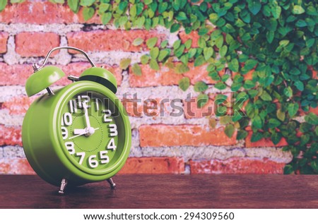 Clock on Wooden Floor with Plant and Brick Wall Background , Vintage Style