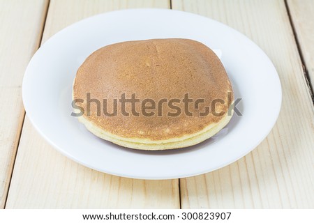 Dorayaki on white dish over wood background, Japanese Sweet Bean Pancakes