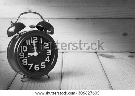 alarm clock on wood background , black and white tone