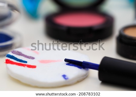 Cosmetic scenery on table, focus on nail polish brush with cotton pad