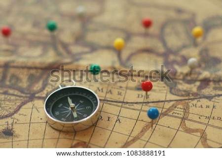 Compass and pins point with vintage map background, journey concept