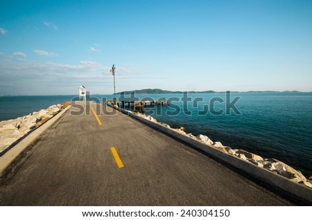 Road into the sea with lighthouse