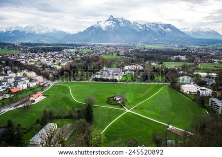 Village with lawn and Alps range background in Austria