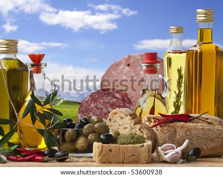Decorative Italian deli with 5 different Olive Oil, Italian Bread, Italian Baloney and Salami, Olive and ingredient on a Landscape Background.