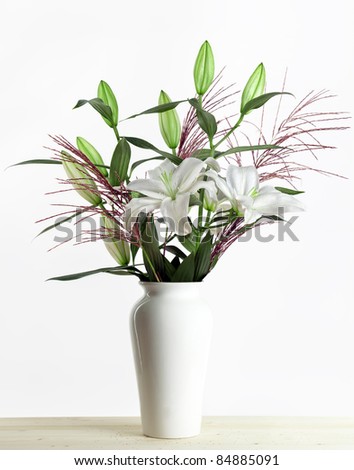 Bouquet of white lilies in a white vase on white Background