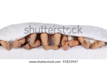 Closeup of Baby Doll \'s bare feet in bed isolated on white