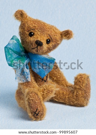 Cute little Teddy Bear toy on blue background