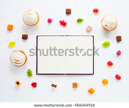 Notebook, candied fruit jelly and cakes isolated on white background. Flat lay of sweets. Mock up for art works. Top view background.