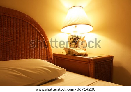 Bed and beautiful bedside lamp in bedroom at night