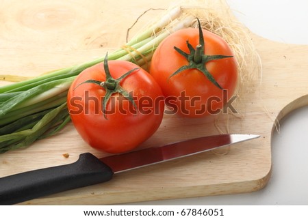 Healthy food. Cutting tomatoes on the wooden board