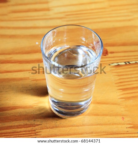 The glass of water isolated on the wooden table