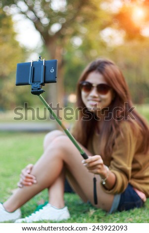 women hold monopod use smart phone take photograph selfie stick in park