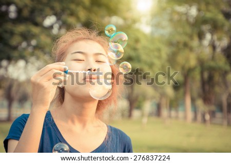 young woman play blowing bubble outdoor lifestyle vintage color