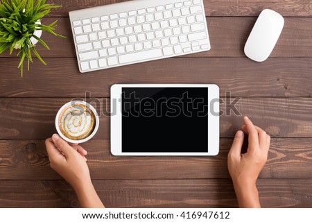 hand using white tablet blank screen on table workspace