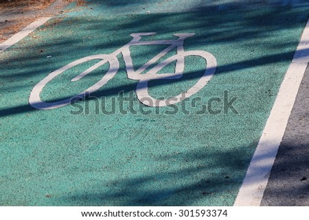 Green painted lane with a painted white bicycle indicating a cycle lane or bicycle route