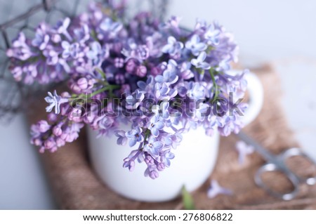 Bouquet of purple lilac spring flowers with an  book and vintage hazy editing